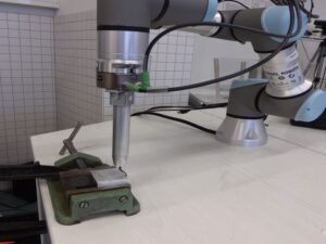 Roboter bedient Entgratwerkzeug am Werkstück